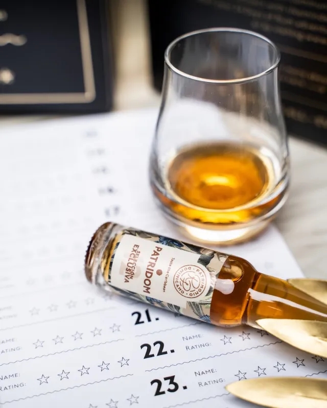Glass and miniature bottle next to the tasting sheet in the advent calendar