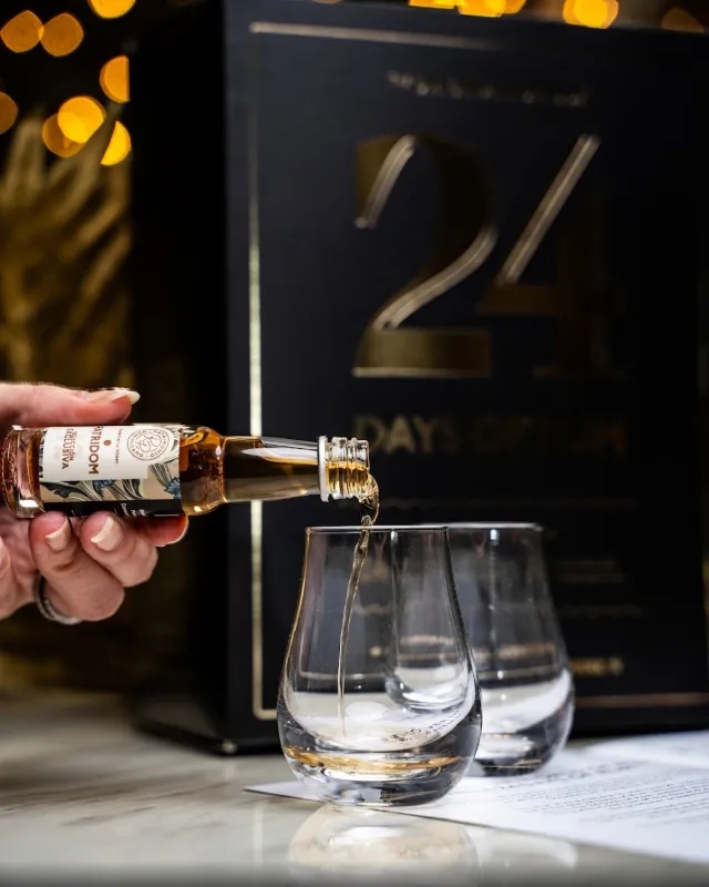 Miniature bottle poured into two glasses from 24 Days of Rum Black Edition